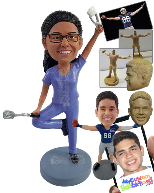 Multitasking Yoga dentist wearing scrubs and holding a dental tool and a spatula on the other hand Personalized Bobblehead